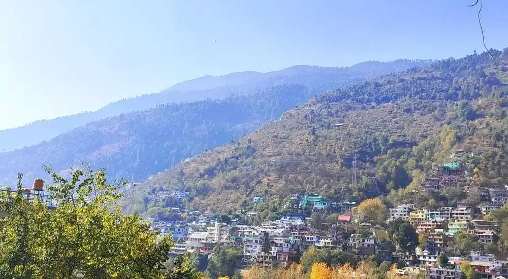 A picturesque view of Manali town with snow-covered mountains.