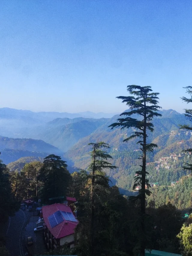 A misty morning in Shimla with sunlight filtering through the hills.