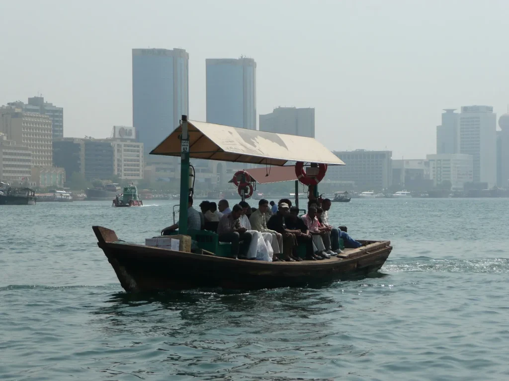 A wooden abra boat carrying passengers across Dubai Creek