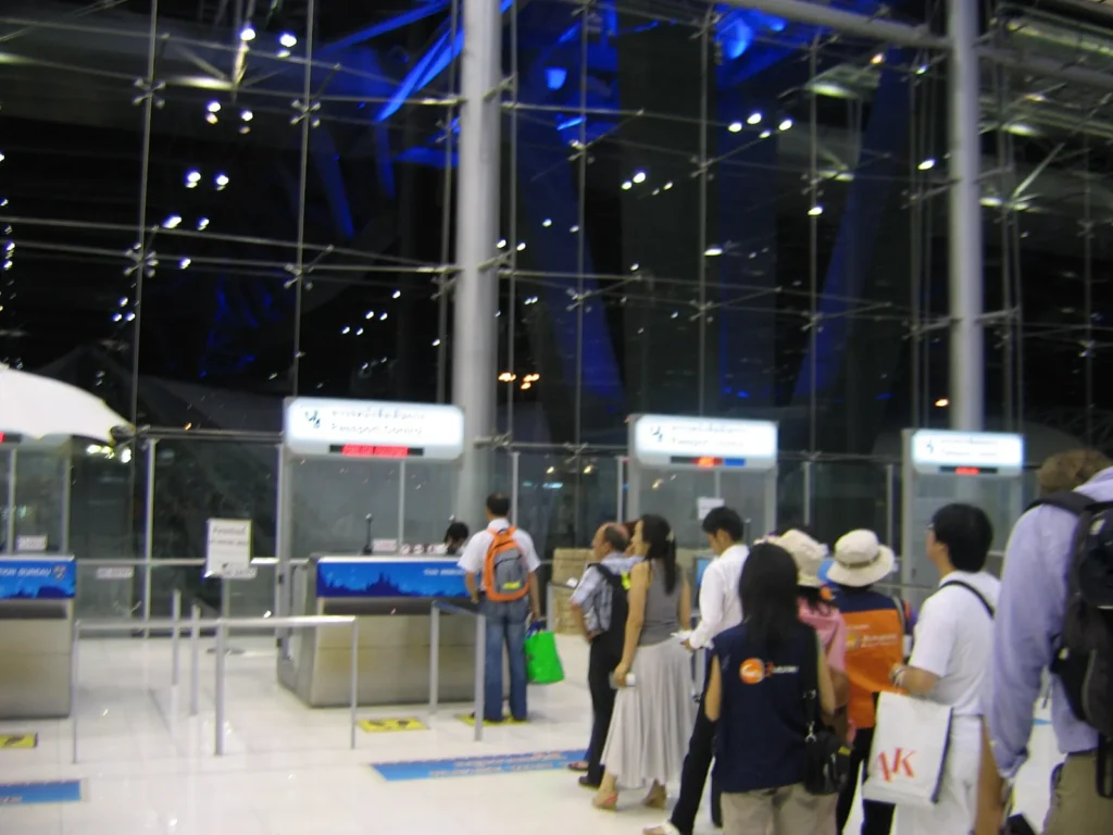 Travellers queuing at passport control counters at Bangkok airport