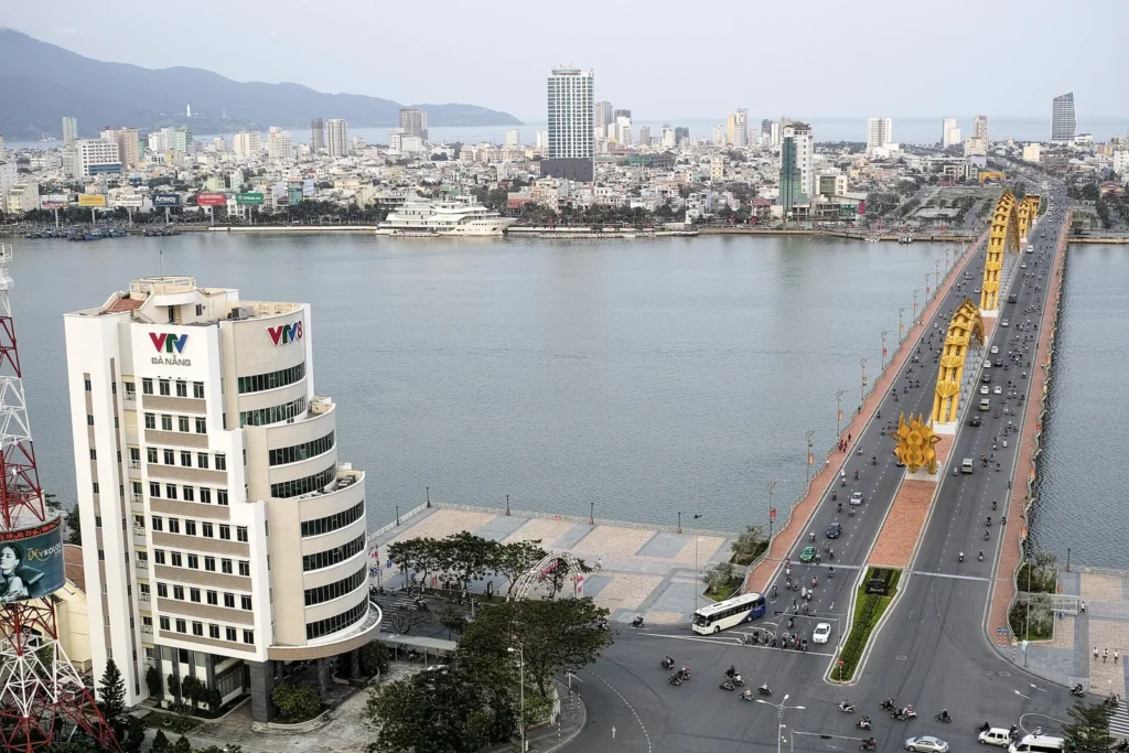 The yellow Dragon Bridge crossing the Han River in Da Nang with the city behind