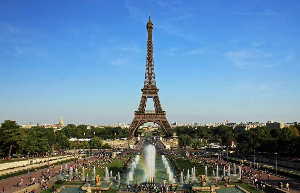 The Eiffel Tower seen across the Trocadero gardens and fountains under a blue sky