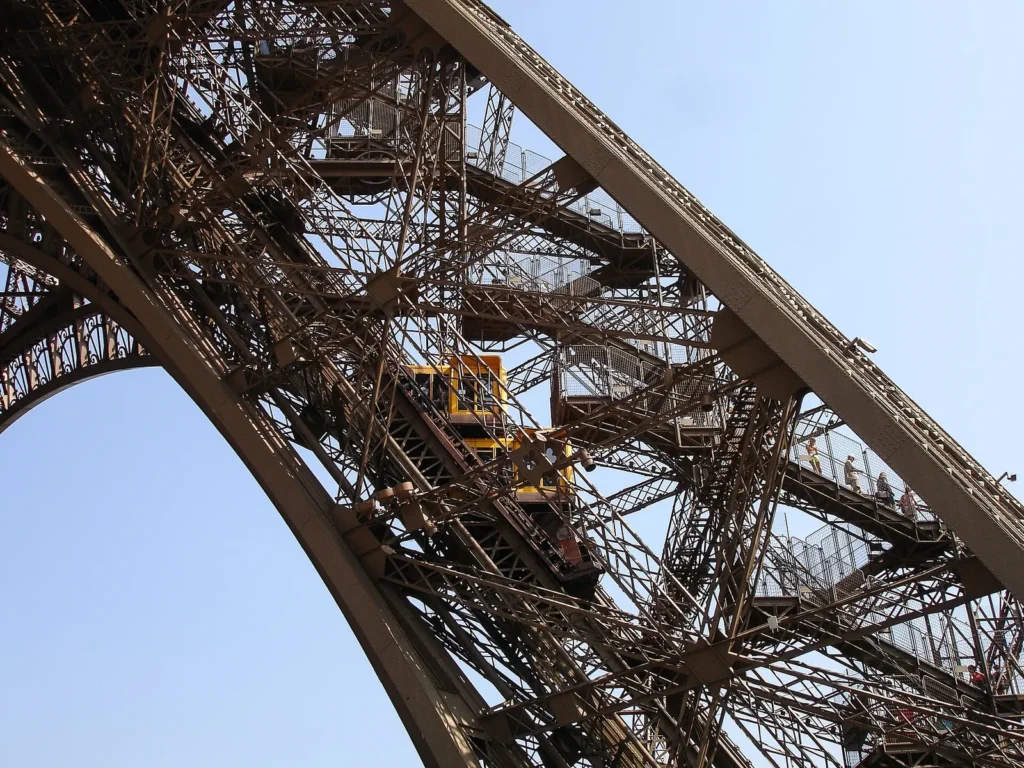 Looking up through the iron girders of the Eiffel Tower where the stairs and lifts run