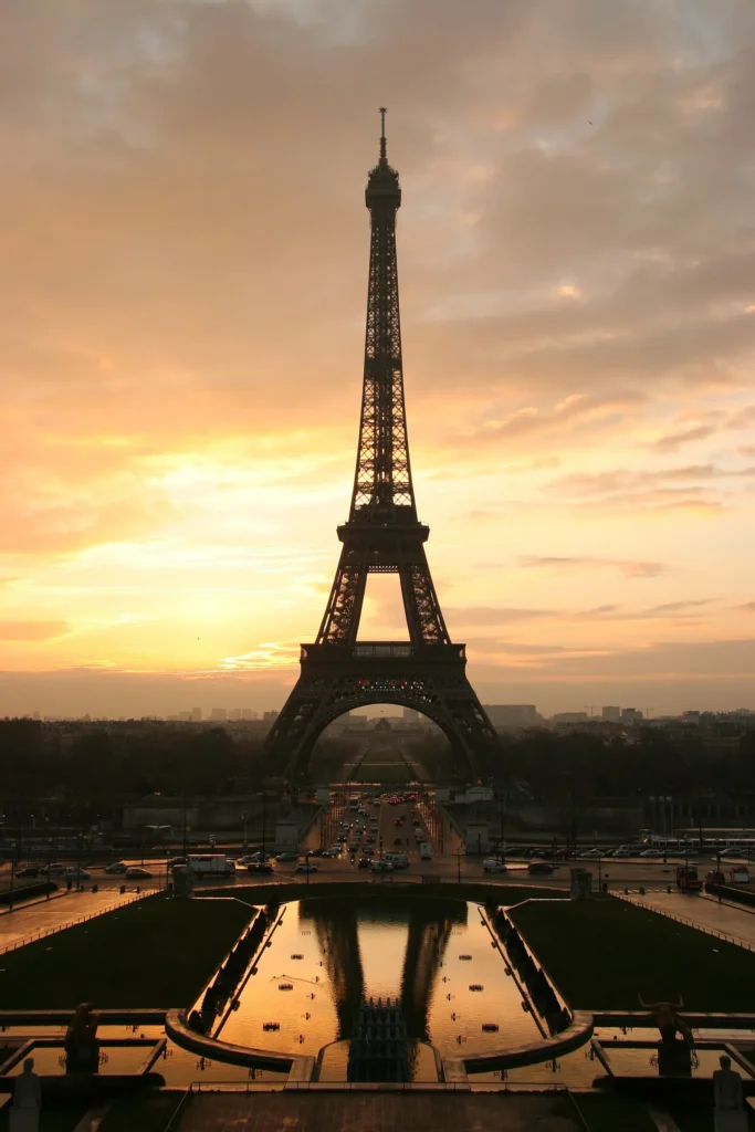 The Eiffel Tower silhouetted against a sunrise sky, seen from the Trocadero