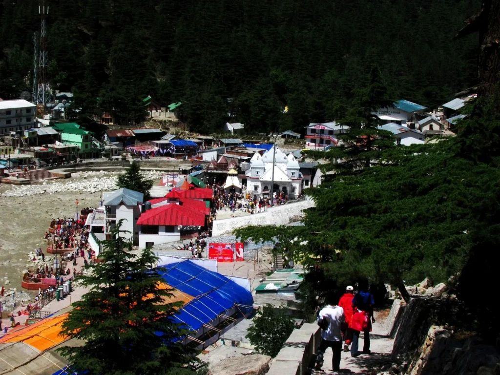 White Gangotri temple beside the Bhagirathi river with forested slopes