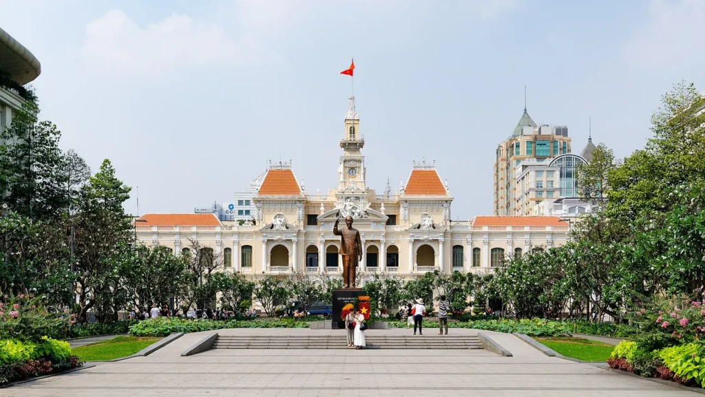The cream and yellow colonial City Hall of Ho Chi Minh City behind a statue and gardens
