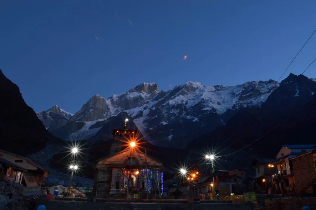 Kedarnath temple at dawn with snow peaks behind it