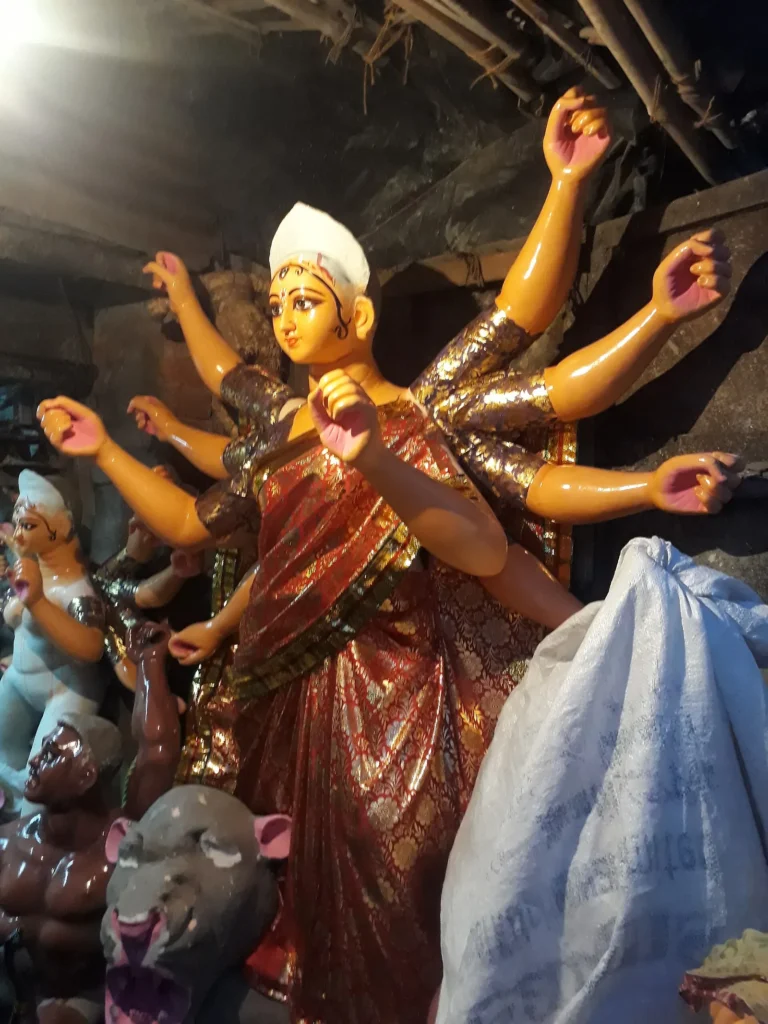 Artisan shaping a clay Durga idol in a Kumartuli workshop