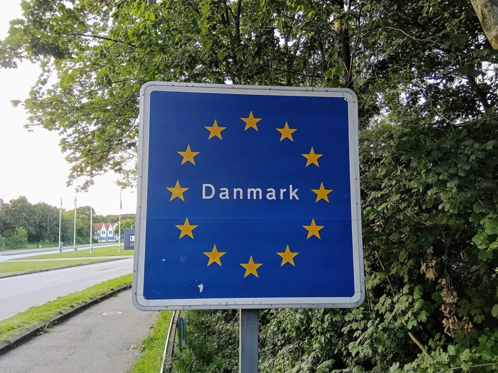 A blue road sign with EU stars marking the Danish border at Kruså