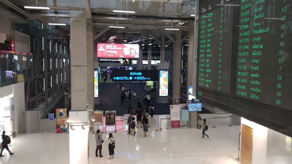 Arrivals immigration hall at Bangkok Suvarnabhumi Airport with signboards and passengers